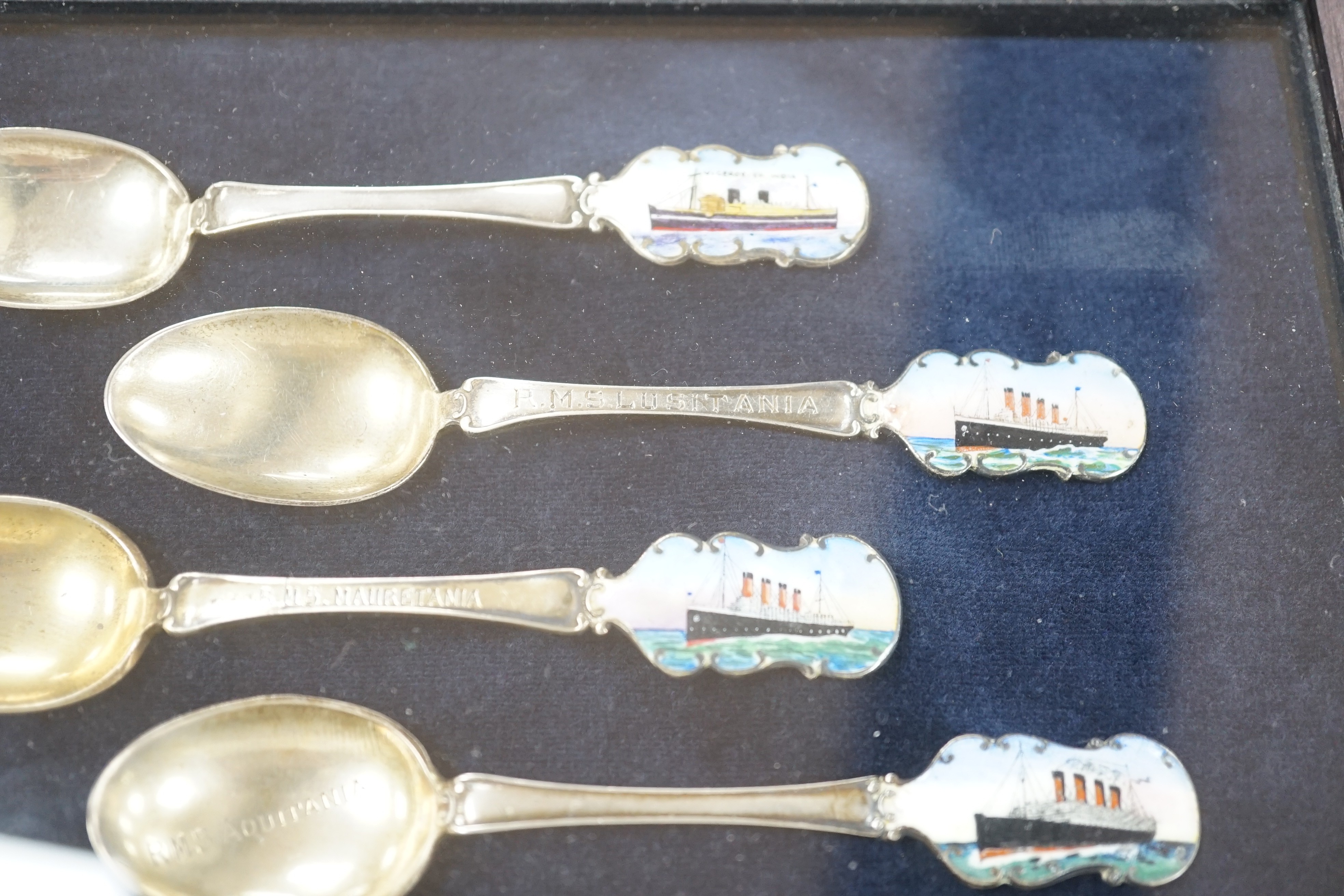 Cunard and P&O liners interest - four early 20th century silver and enamel souvenir spoons, inscribed RMS Lusitania, RMS Aquitania, RMS Mauretania and Viceroy of India, cased